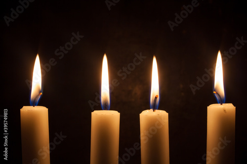 Four candles burning with black background