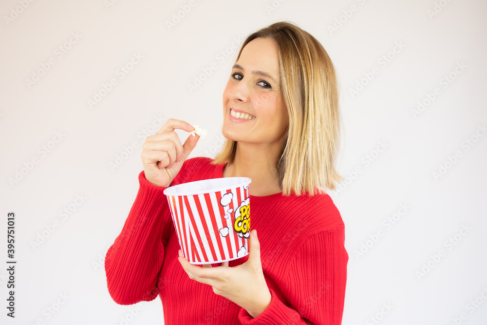 Beautiful blonde woman holding pop corn, isolated over white background
