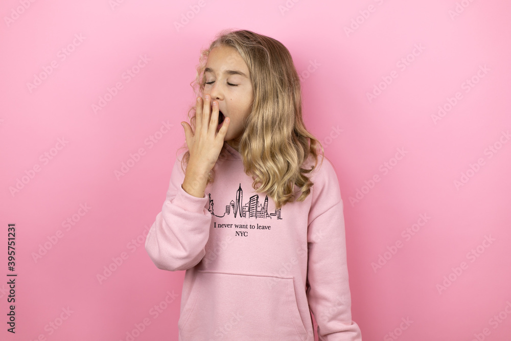 Young beautiful child girl standing over isolated pink background bored yawning tired covering mouth with hand. Restless and sleepiness. Young beautiful child girl standing over isolated pink background bored yawning tired covering mouth with hand. Restless and sleepiness.