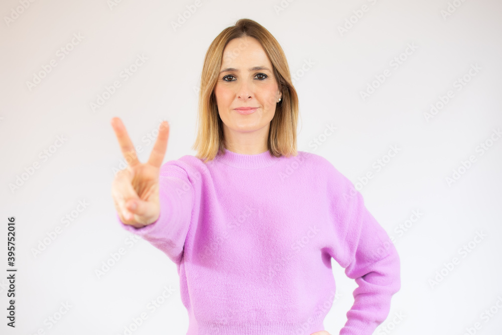 Young woman isolated on white background smiling and showing victory sign Young woman isolated on white background smiling and showing victory sign