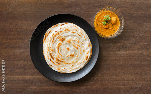 South Indian Parota on a black plate, served with paneer curry for a quick meal. photo