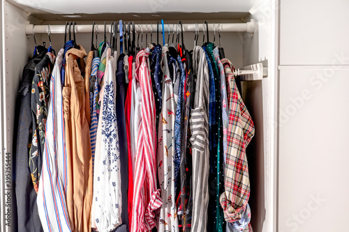 Open wardrobe wardrobe with women's colored shirts © KseniaJoyg
