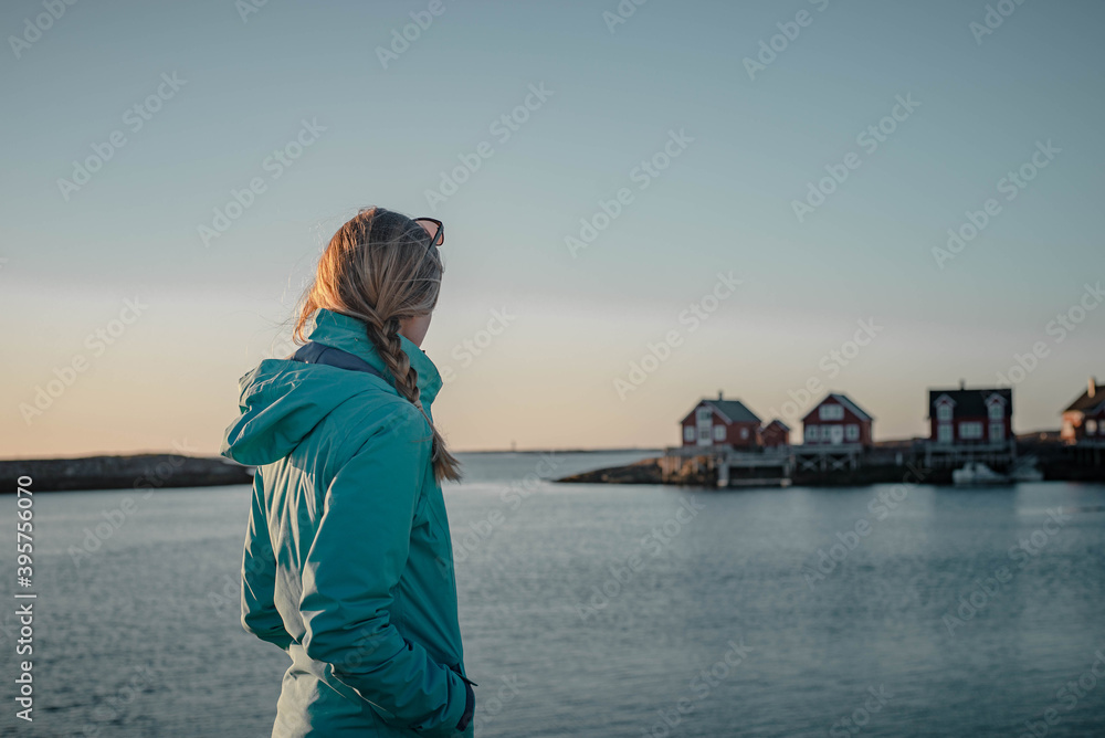 Woman with braided hair is enjoying view of beautiful holiday houses in Norway