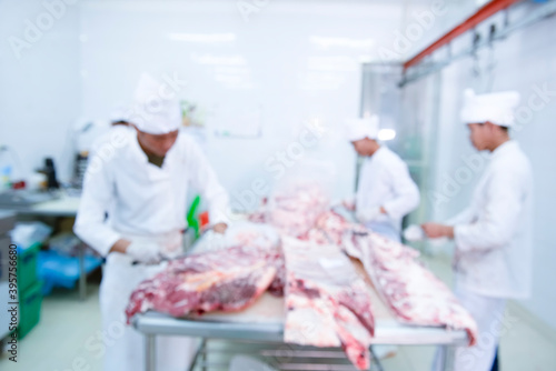 The image is blurry  a group of butchers working in slaughterhouses and cutting fresh Japanese wagyu beef for sale and processing.