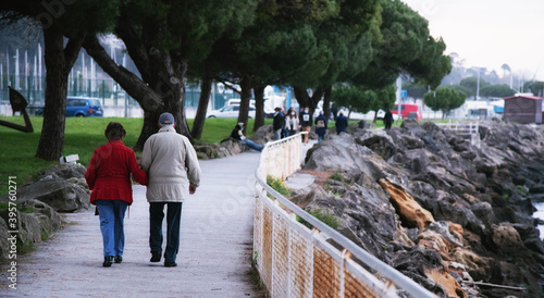 Fotografie Abuelos paseando por la costa, con unos jóvenes al fondo.
