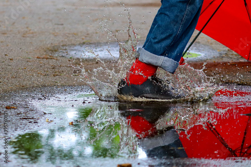 Splashing in puddles with red socks and a red umbrella.