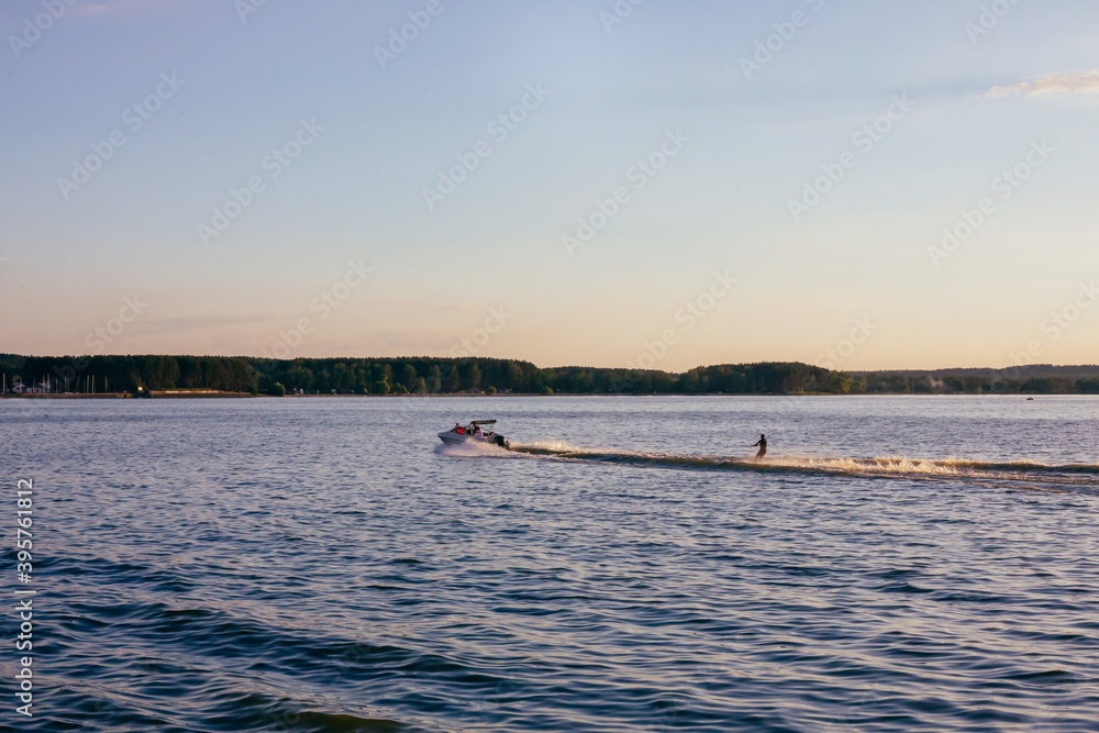 Water skiing on lake behind a boat.