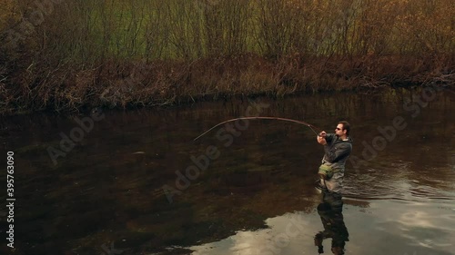 Aerial Forward Shot Fully Equipped Fisherman Pulling the Fishing Line photo