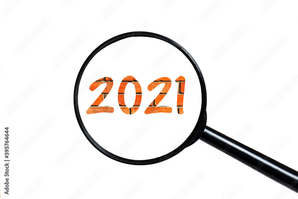 number 2021 and magnifying glass on white background. text on brick wall number 2021 and magnifying glass on white background. text on brick wall