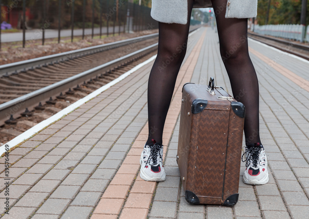 © Radnatt - woman in gray coat and with a suitcase stands at railway station. legs closeup © Radnatt - woman in gray coat and with a suitcase stands at railway station. legs closeup