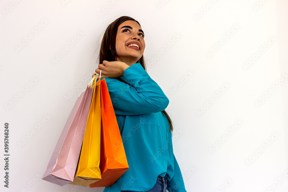 Pretty smiling woman with shopping bags over white background.Christmas,sale and retail concept.Young cheerful shopaholic Caucasian girl with lots of shopping bags isolated on white studio background.