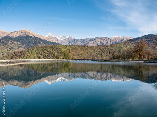 Water reflection of mountains in Rosa Khutor resort at sunny day