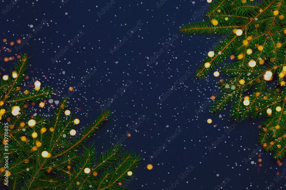 Christmas, New year, winter frame with fir tree branches, snow and lights on dark blue background. Holiday concept. Flat lay, top view with copy space Christmas, New year, winter frame with fir tree branches, snow and lights on dark blue background. Holiday concept. Flat lay, top view with copy space