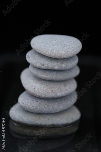 Zen Stones.spa stones set in water on black background. Harmony  balance and balance. Beauty and health.Gray stones column on black background