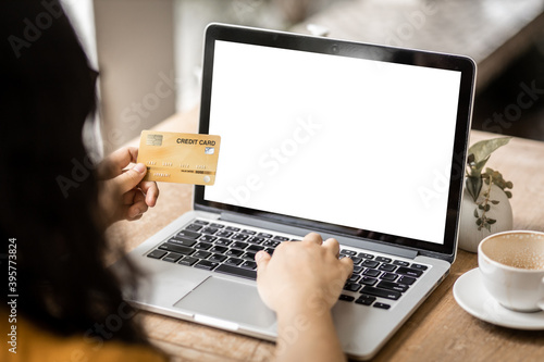 Close-up of freelance people business female Hand holding Credit cards casual working using with laptop computer with a blank white screen in coffee shop like the background,Online payment shopping
