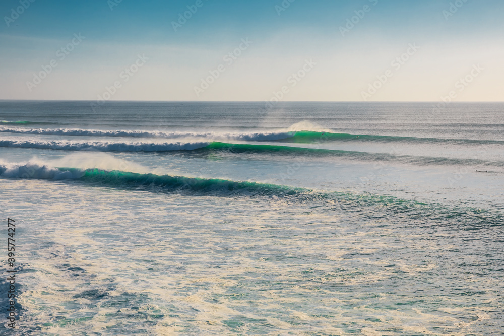 Obraz premium Big and long waves in ocean. Ideal swell for surfing