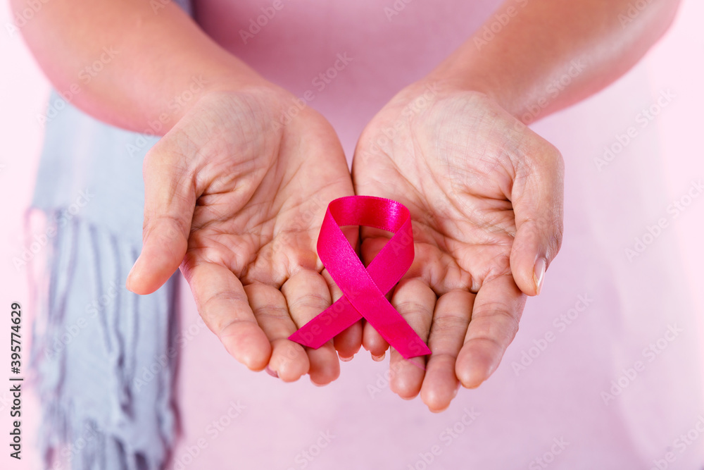 closeup of Woman holding pink ribbon in pullover holding pink ribbon isolated on pink blank copy space studio background,healthcare,medicine concept closeup of Woman holding pink ribbon in pullover holding pink ribbon isolated on pink blank copy space studio background,healthcare,medicine concept