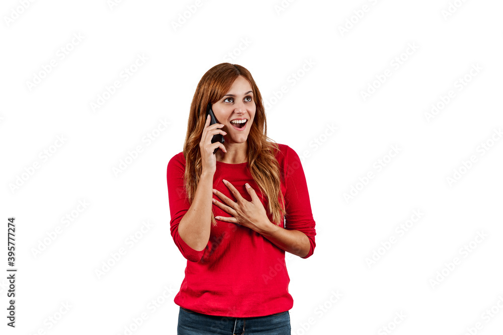 Beautiful young woman in a red sweater, surprised while talking on the phone, isolated on a white background. Beautiful young woman in a red sweater, surprised while talking on the phone, isolated on a white background.