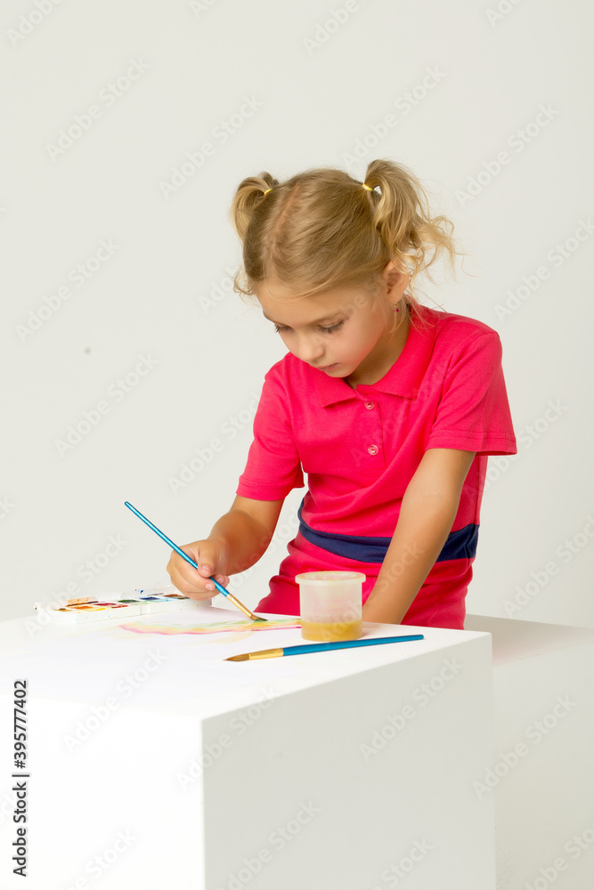 Beautiful Blonde Girl Standing at Table and Painting with Watercolor Beautiful Blonde Girl Standing at Table and Painting with Watercolor