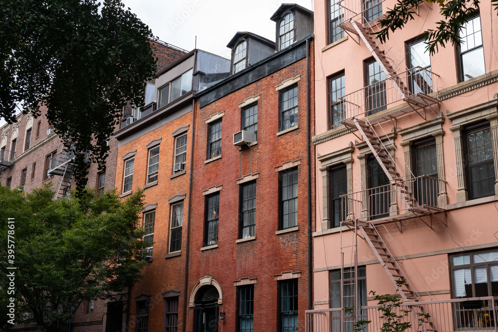 Fototapeta premium Row of Colorful Old Brick Apartment Buildings with Fire Escapes in Greenwich Village of New York City