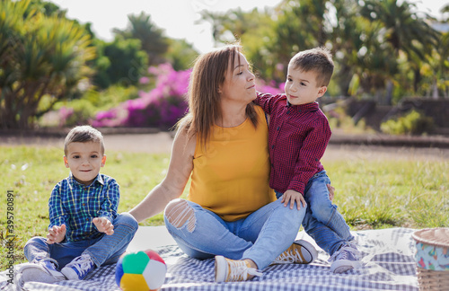 Happy young family enjoy day together in nature park with pic nic - Mother and children love - Twins photo