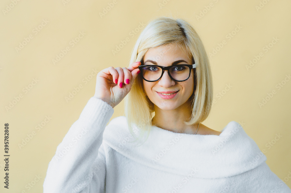 Portrait of pleased attractive smiling Cute young European woman holding cat-eye glasses posing, isolated over light green studio background. Stylish curly blonde young European woman holding specks