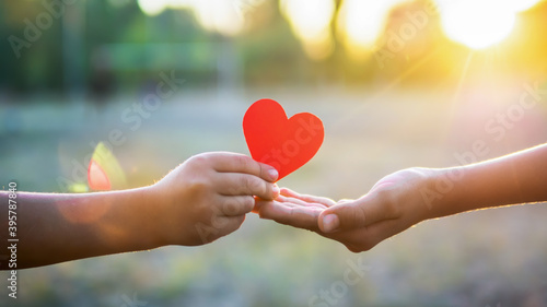 A kid is giving a man a red heart