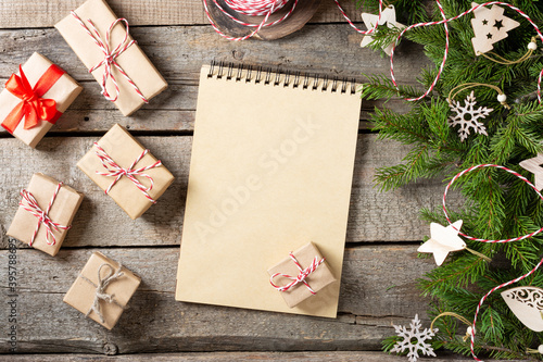 Christmas or new Year background with an open blank Notepad, spruce branches and Christmas ecofriendly wooden decorations. A checklist or a letter to Santa. Christmas business greeting card. Copyspace