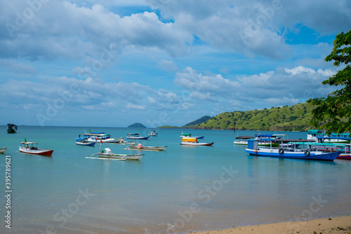 A Paradise island, tropical beach, emerald green sea with beach trees and blue sky background, Indonesia, south asia. Local people have a simple life like fishermen and sellers. Indonesia, South Asia