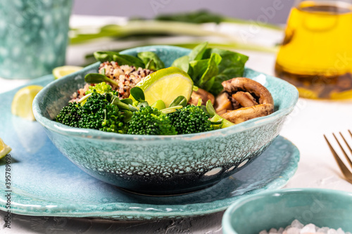Quinoa salad in bowl with broccoli  mushrooms and spinach on a light background. Quinoa superfood concept. Clean healthy detox eating. Vegan vegetarian food. Top view