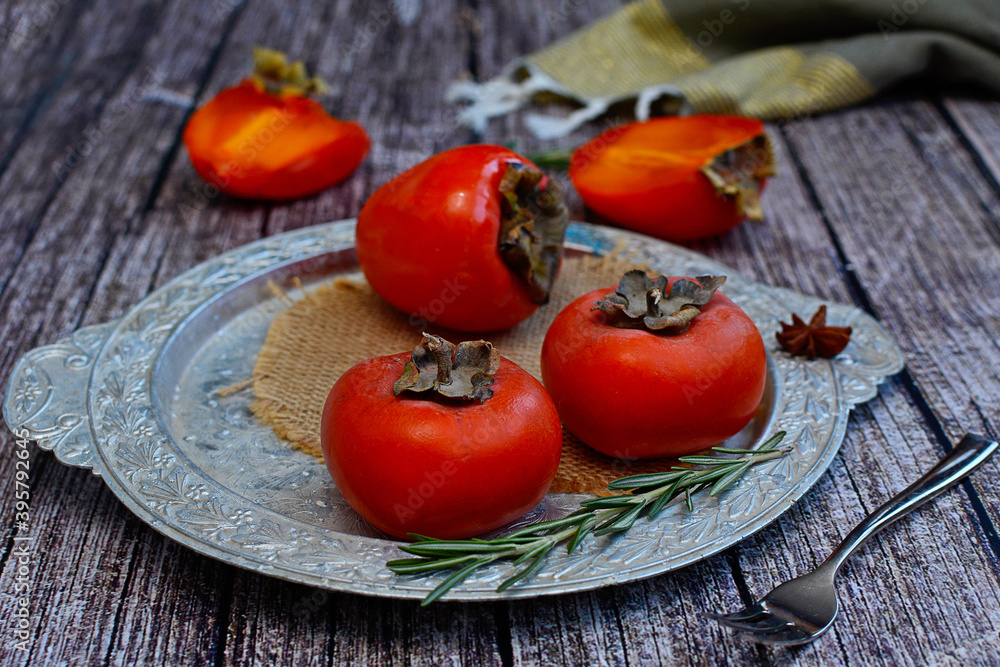 Bright, ripe persimmons on a silver platter. Healthy food concept Bright, ripe persimmons on a silver platter. Healthy food concept