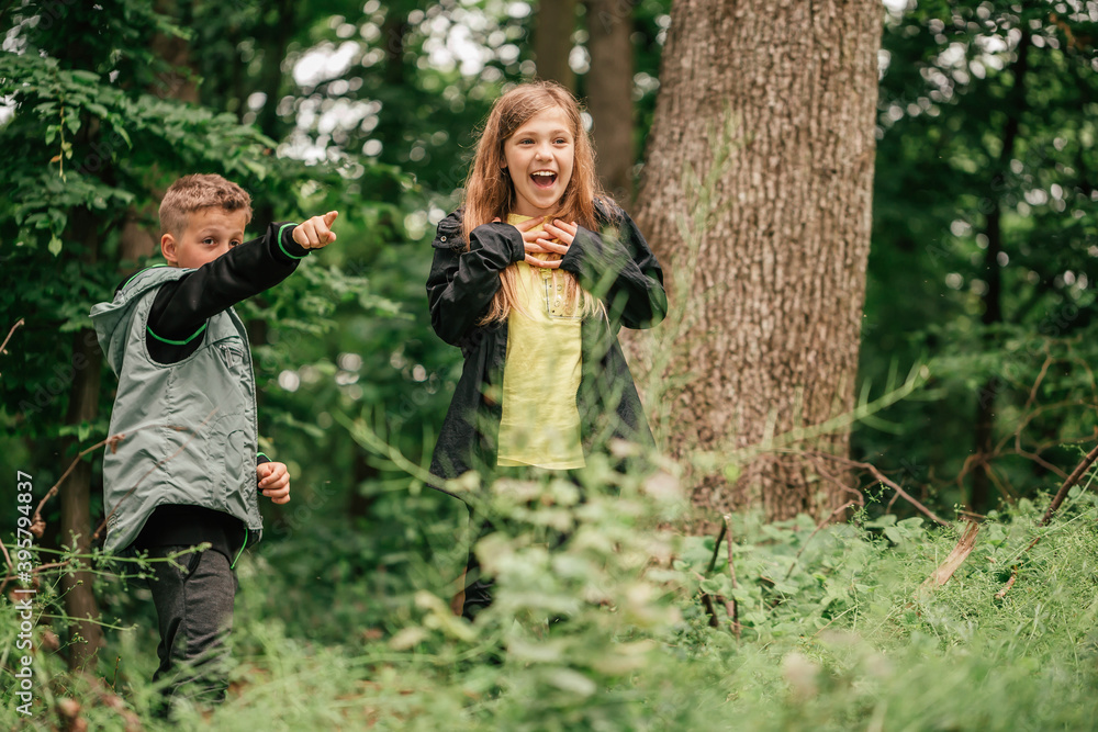 Happy little friends walking and having fun in spring forest