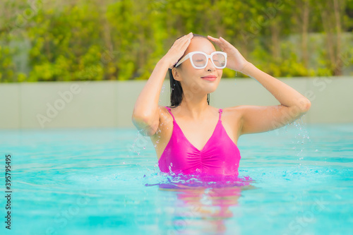 Portrait beautiful young asian woman relax smile around outdoor swimming pool in hotel resort © siraphol