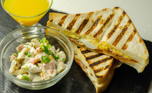 White bread with beechwood smoked bacon, egg, mayonnaise, and tomato served with Caesar pasta with parmesan cheese photo