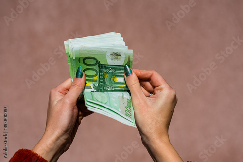 Hand couting holding and showing euro money or giving money. World money concept, 100 EURO banknotes EUR currency isolated with copy space. Concept of rich business people, saving or spending money. photo