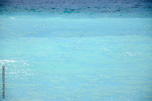 Turquoise water of tropical sea Waves on the water. Mediterranean coast. Waves breaking on the shore. Surface of a deep blue ocean.