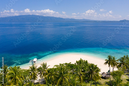 Perfect white sand beach with tropical trees. Mahaba Island, Philippines.