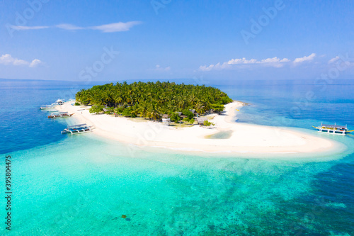 Island with a tropical beach and turquoise lagoons. Tropical island on a coral reef  top view.