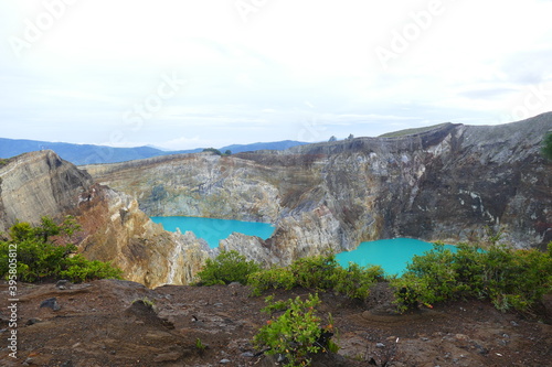 photo picture of a beautiful amazing delightful volcanic multicolor lake in the crater of a volcano Lake Kelimutu National Park Island of Flores against the backdrop of a wonderful skyline.