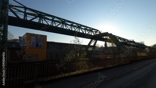 camera following metalic structure over water in a post industrial city with factory and smoke, and backlight