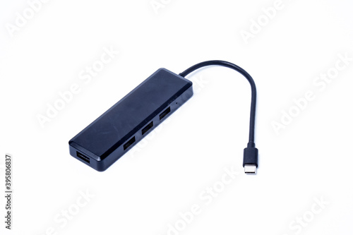 The black color of the multi USB type-c hub converter to the laptop. Isolated on a white background