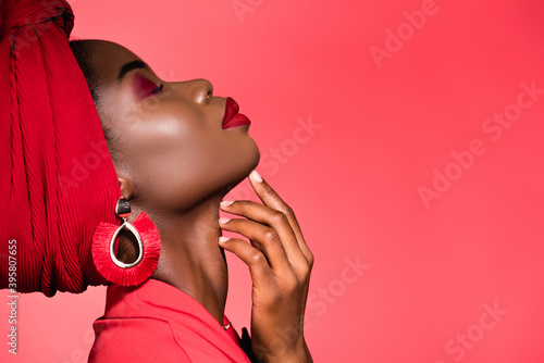 Fototapeta profile of african american woman in stylish outfit and turban with closed eyes