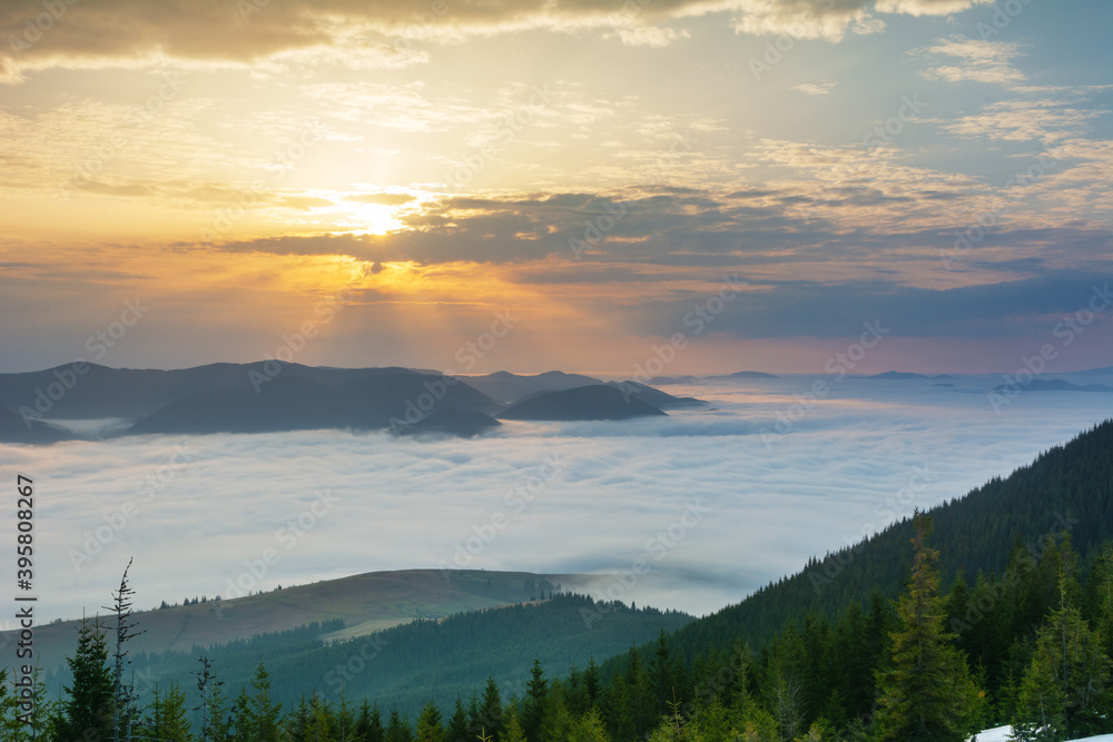 Obraz premium Beautiful sunrise in the Carpathian mountains with fog and dramatic sky