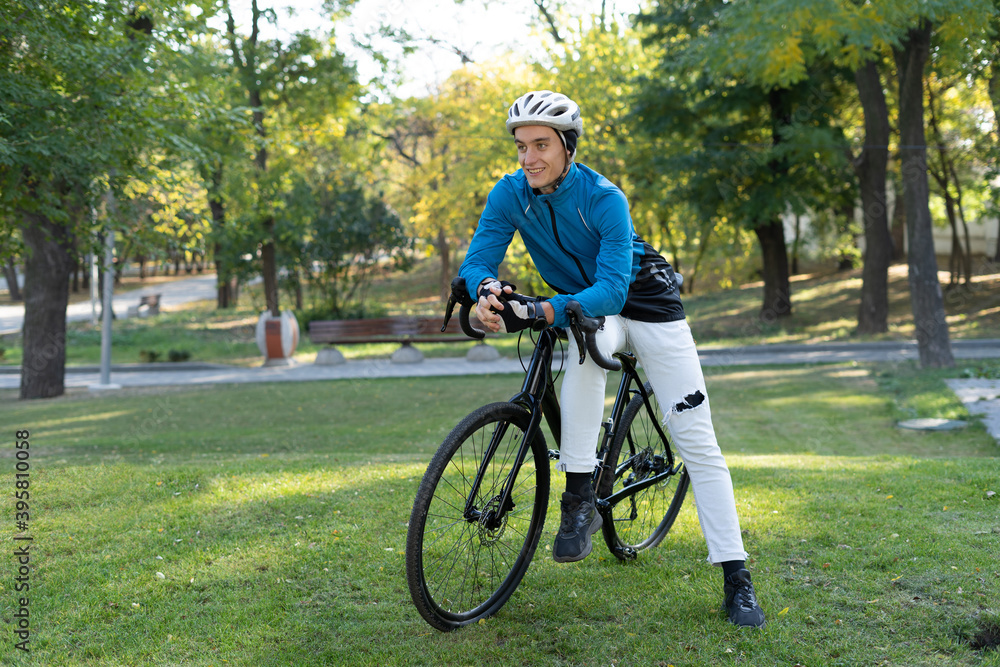 Obraz premium a young man of European appearance sat down on a bicycle frame. active lifestyle.