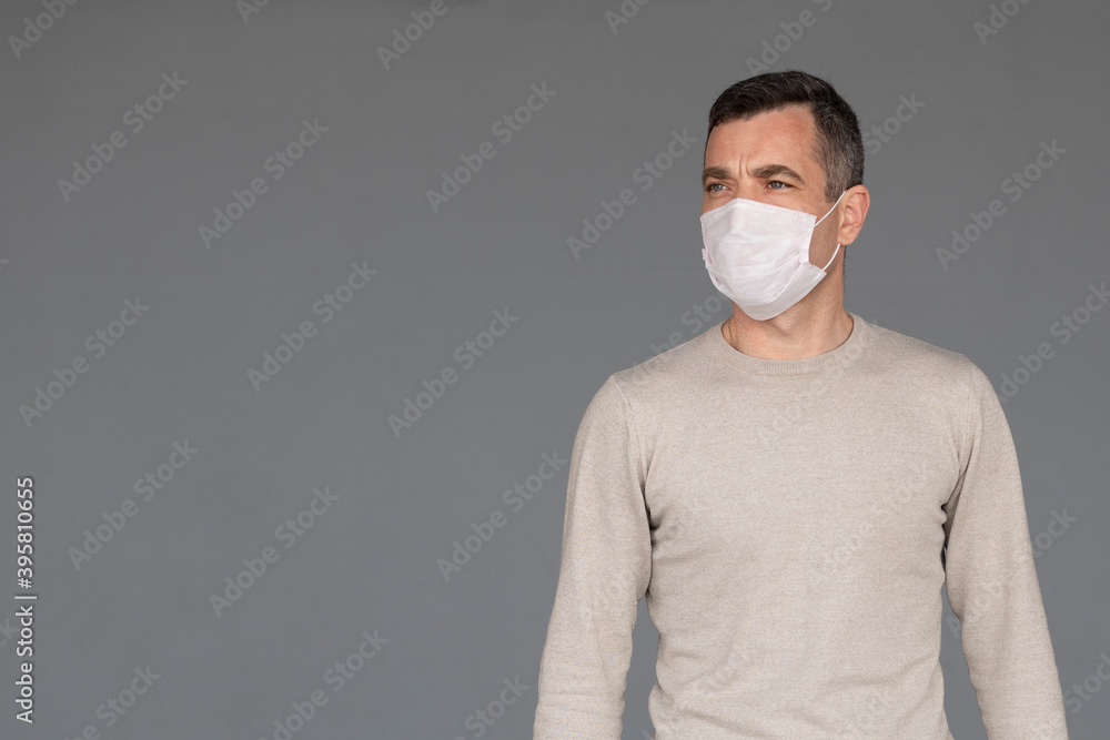Man wearing surgical face mask isolated on grey Man wearing surgical face mask isolated on grey