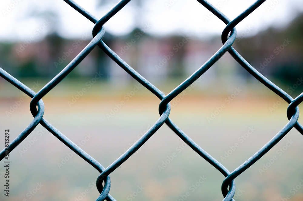 Geometrical grey-green wire fence in close-up at tennis court Geometrical grey-green wire fence in close-up at tennis court