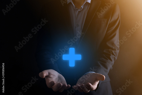 Businessman, man hold in hand offer positive thing such as profit, benefits, development, CSR represented by plus sign.The hand shows the plus sign