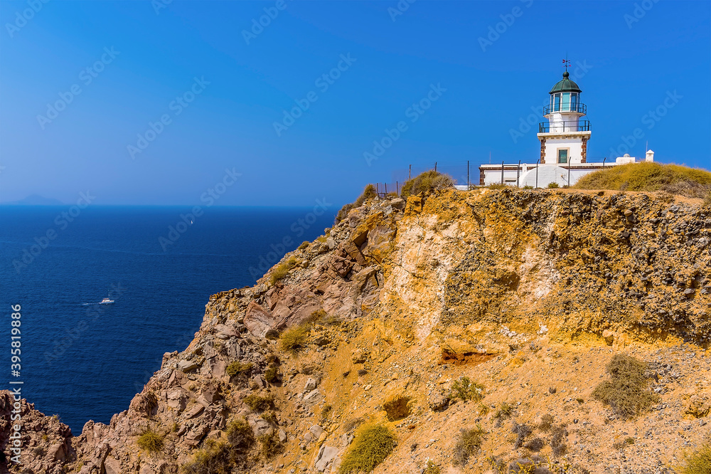 A view of the lighthouse at Akortiri at the end of the caldera rim in Santorini in summertime