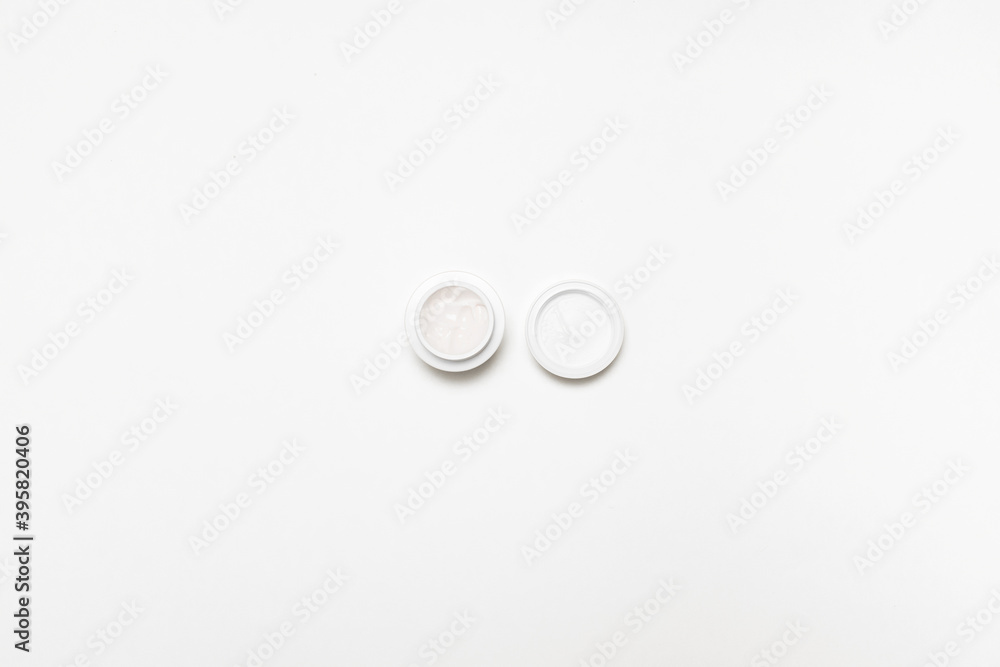 White plastic jar with moisturizing protective cream for face and body on gray background White plastic jar with moisturizing protective cream for face and body on gray background