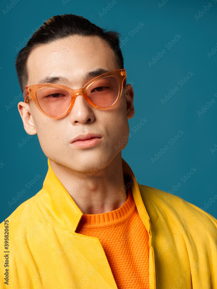 Fototapeta premium Fashionable men with glasses Asian appearance portrait Blue background